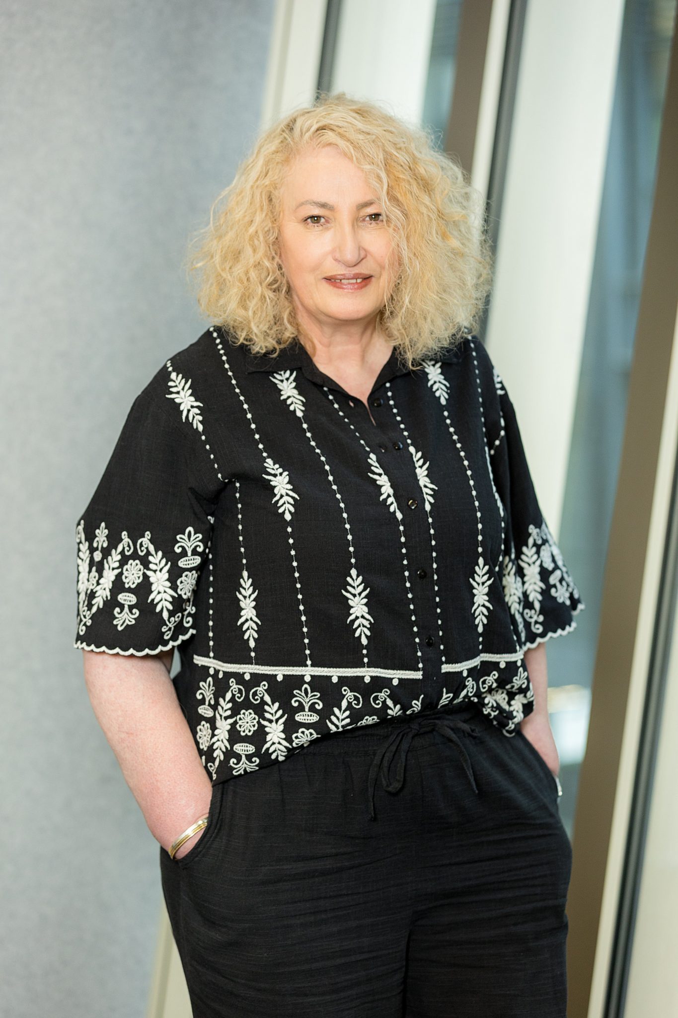 An image of Melanie Chart standing with her hands in her pocket and smiling at the camera.