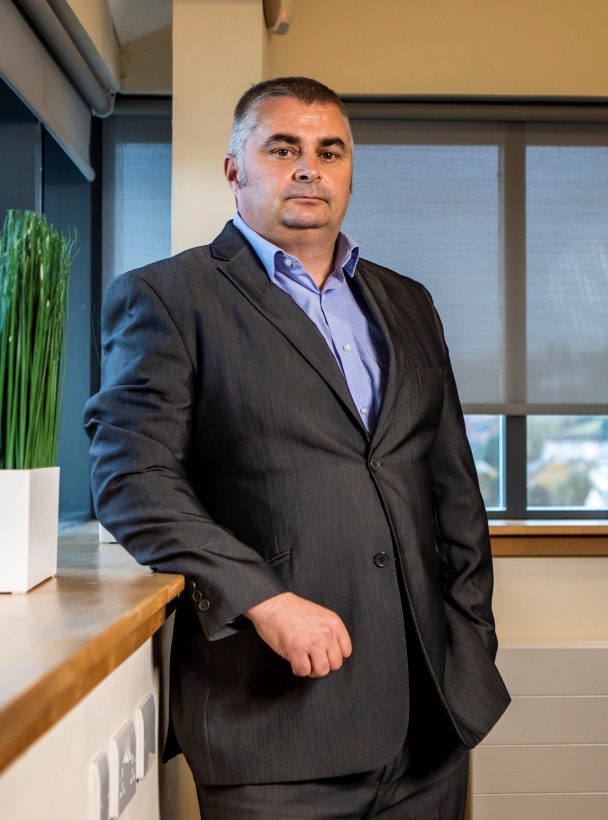 David Carr standing in the office leaning against a window ledge