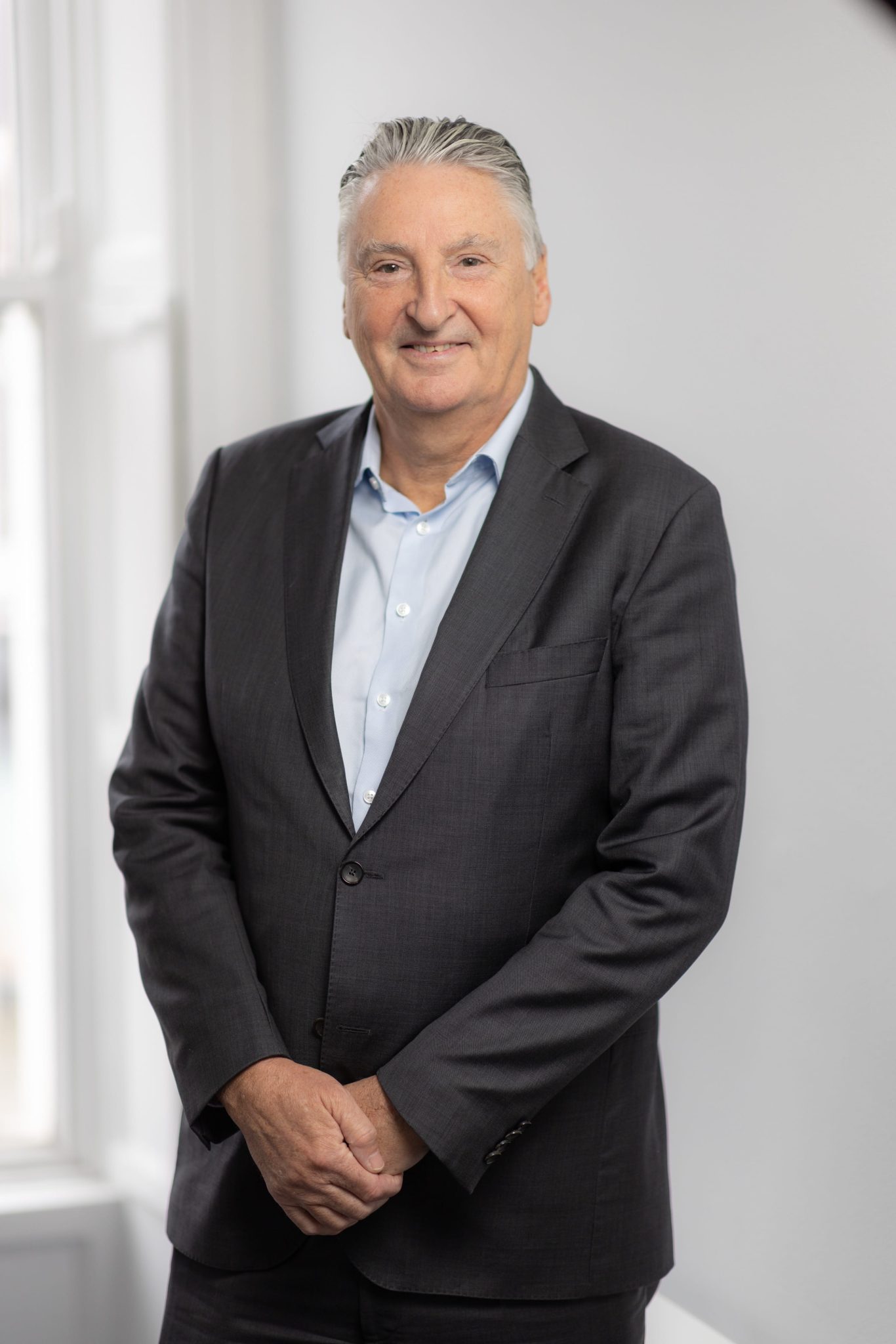 An image pf David Marsh wearing a black suit jacket and white shirt. He is smiling at the camera.