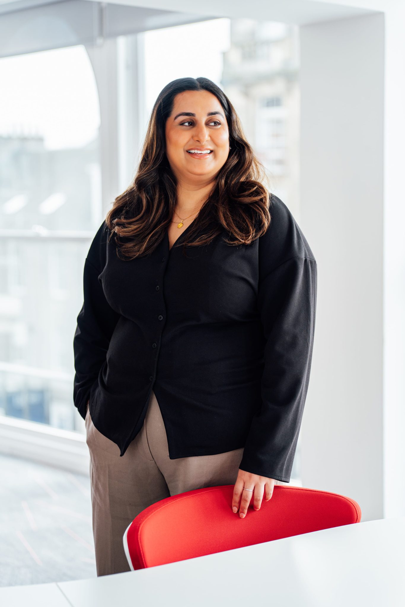 An image of Tahreem Hamid standing in the office and looking out the window.